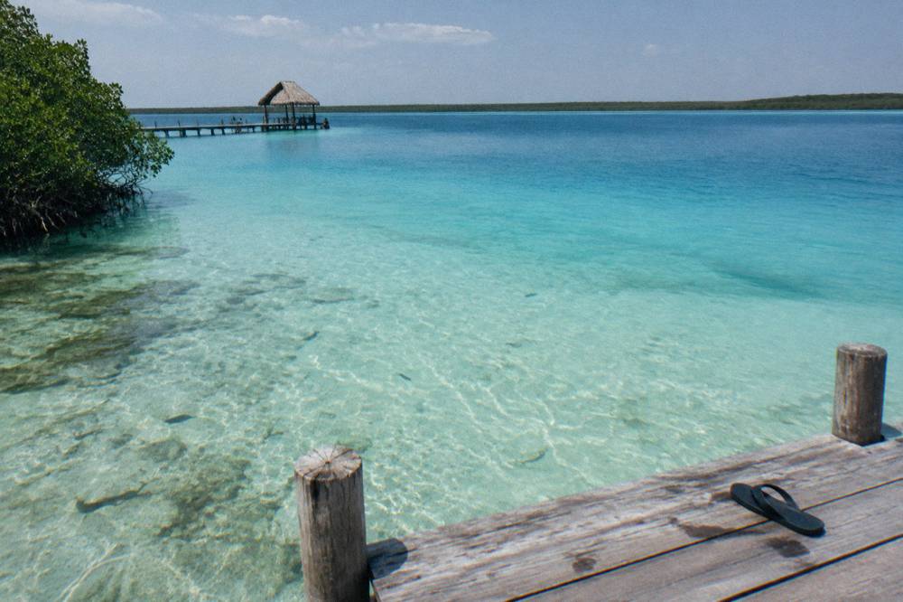 Layered bands of pale and deep blue shallow water over pale sand in a freshwater lagoon
