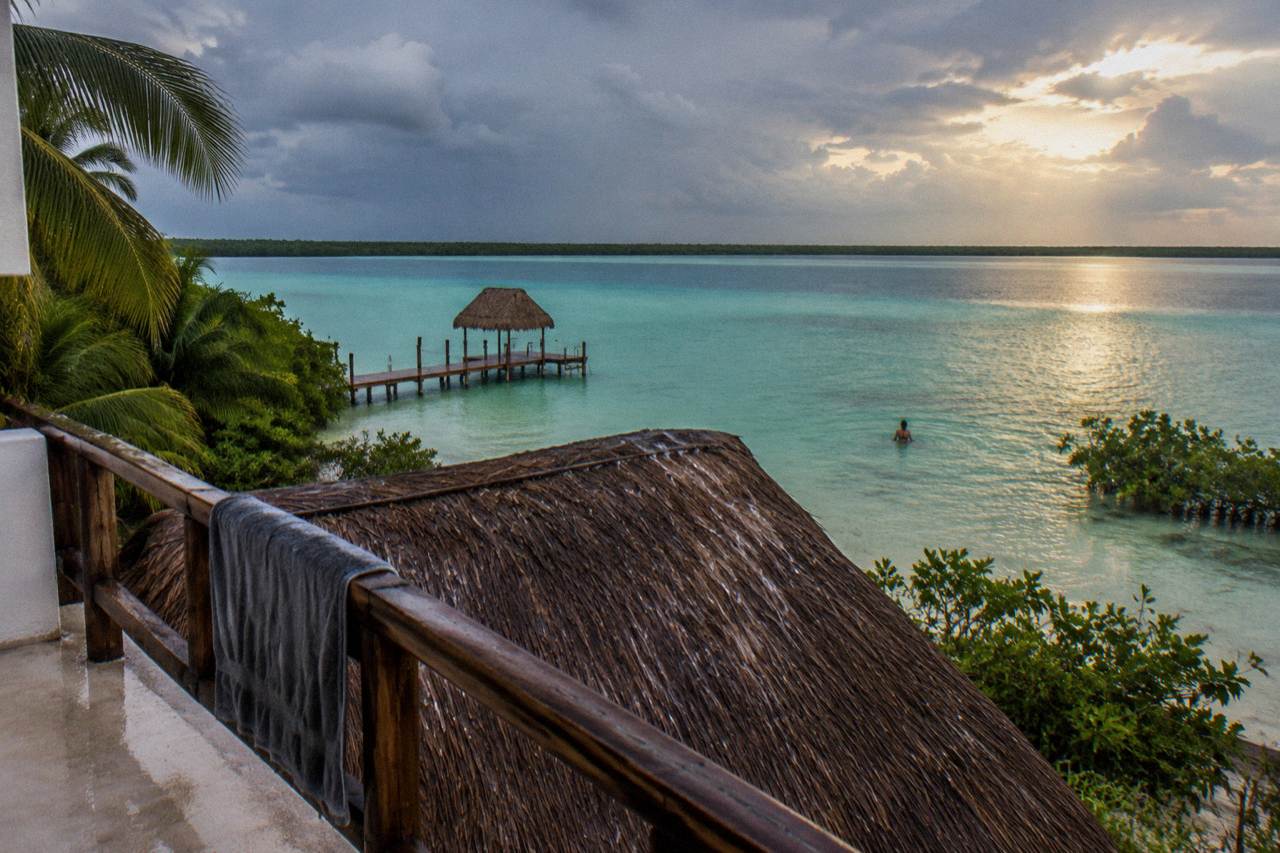Calm turquoise freshwater lagoon stretching toward a distant treeline under a clear sky