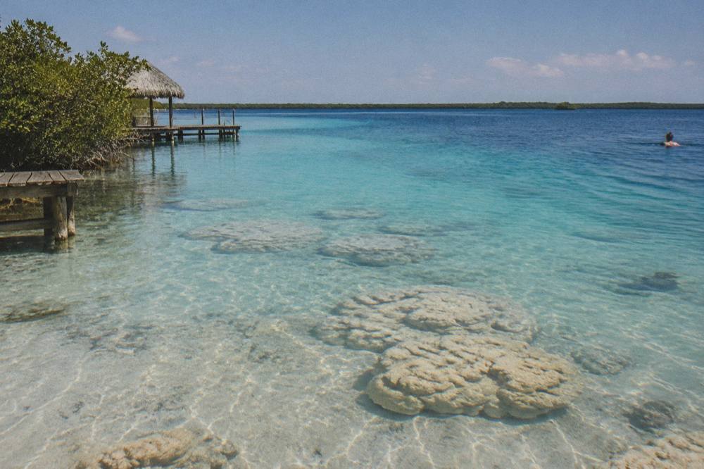 Shallow turquoise water over a pale sandy bottom fading into deeper blue toward the middle of Bacalar Lagoon