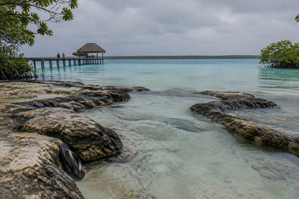 Shallow turquoise channel with white rock bed and dark microbialite rims along the edge