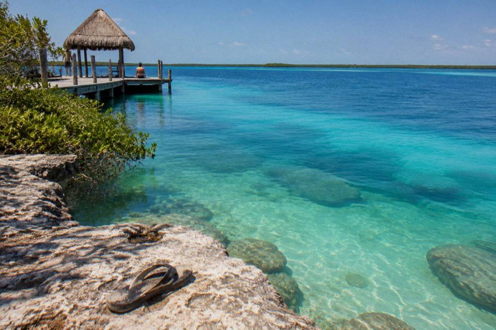 Turquoise and deep blue colour bands visible in Bacalar Lagoon water under midday sun
