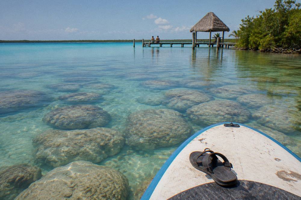Dome-shaped rock formations visible beneath clear shallow lagoon water