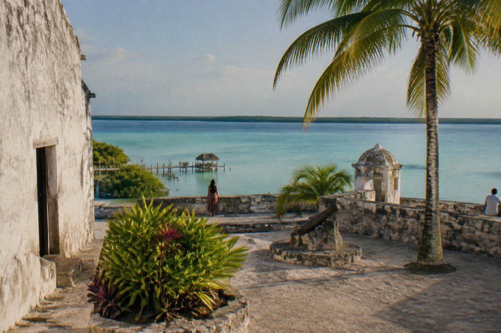 Colourful colonial buildings and a quiet town square in Bacalar in late afternoon light
