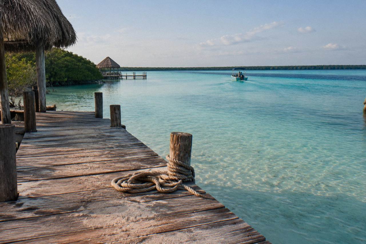 Turquoise water of Bacalar lagoon seen from a wooden dock at morning